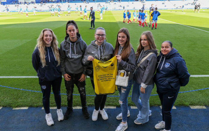 Premier League Inspires students standing on the pitch edge